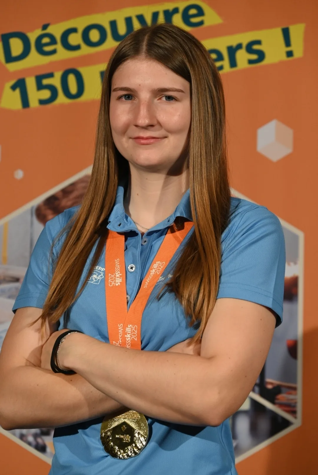Die junge Malerin Nadine Bünzli wusste schon früh, dass sie sich für ein Handwerk entscheiden würde. Dies, wie sich zeigt, mehr als erfolgreich. Eine junge Frau mit Medaille und blauem Shirt.